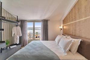 罗希姆诺PORTA SQUERO Premium Suites的一间带大床的卧室和一个阳台