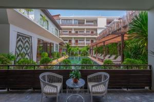 暹粒Siemreap Vasinh Residence的一个带桌椅的阳台和一个游泳池