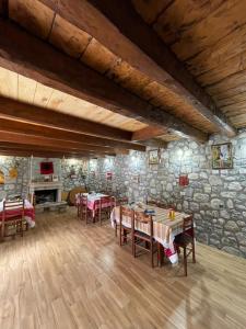 泰斯Guest House Rrashkadoli的一间带桌椅和石墙的用餐室
