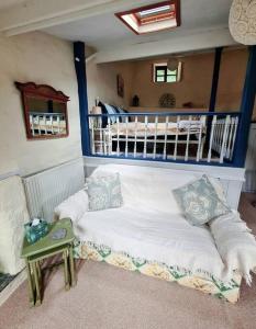 牛顿阿伯特Mill Cottage Garden Annexe的一张带枕头的床铺和一张桌子