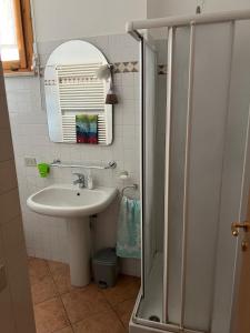 佩萨罗B&B I TRE GATTI的一间带水槽、镜子和淋浴的浴室