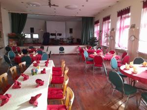 MalschGasthaus Zur Rose的一间摆放着桌椅和红色餐巾的房间