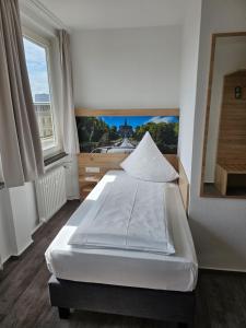 卡塞尔卡塞尔城市酒店的卧室配有白色的床和大窗户