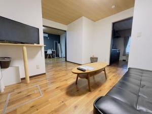 札幌リノベーション済み室内新築　Service Apartment Sapporoザ・ハウス4LDK86㎡的客厅配有桌子和沙发