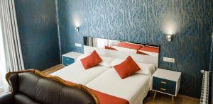 哈卡哈克斯酒店的一间卧室配有一张带红色枕头的大床