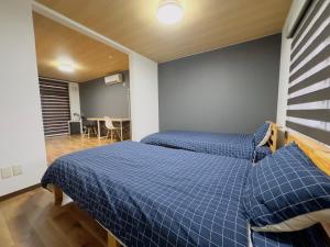 札幌リノベーション済み室内新築　Service Apartment Sapporoザ・ハウス4LDK86㎡的配有蓝色床单的客房内的两张床