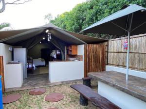 蓬塔杜欧鲁MOZBEVOK Coconut View Resort的一个带桌子和遮阳伞的庭院