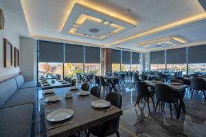 GazligolAfyon Regulus Thermal Apart Hotel & Villas的用餐室设有桌椅和窗户。