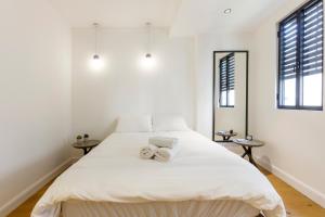 特拉维夫AirTLV - Bazel Central Apartment With Balcony的白色卧室配有一张大床和毛巾