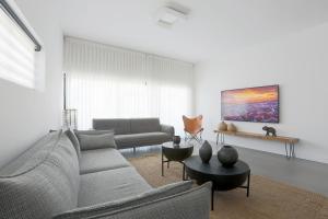 特拉维夫AirTLV - Bazel Central Apartment With Balcony的客厅配有沙发和桌子