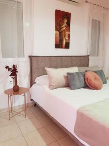 法里拉基Theti Apartment的卧室配有一张床,墙上挂有绘画作品