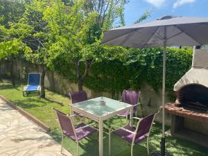 卢贝新城3 Pièces climatisé en rez de jardin avec piscine的后院的桌椅和遮阳伞