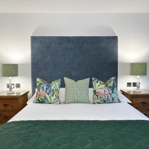 马根波思Merlin Farm Cottages short walk to Mawgan Porth Beach and central location in Cornwall的卧室配有一张带绿床单和枕头的大床。