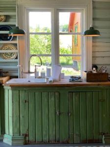 RingsakerVilla Leonore: Sommerhus m/strandlinje på Helgøya的厨房里的一个绿色的柜台,有窗户