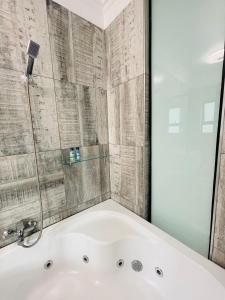 鲁德普特Stay In Carlazo - Unlimited WiFi, Solar backup的带浴缸和玻璃淋浴间的浴室