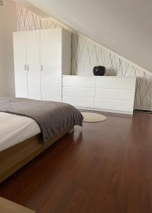 Slivnica pri MariboruApartman Slivnica pri Mariboru的卧室配有1张床和白色橱柜,铺有木地板。