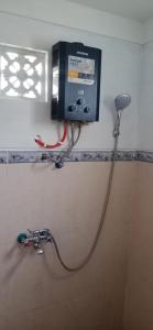 UndisanRindu Homestay的电视机在浴室墙上,有水管