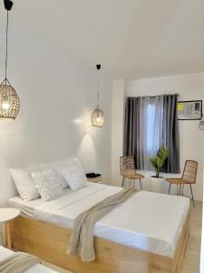 SudtunganNEW Modern Suite near Airport & Beach的一间卧室配有一张带白色床单和椅子的床
