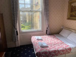 伦敦奥克利酒店的一间卧室配有一张床,上面有两条毛巾