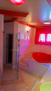 格拉玛多阿维尼达汽车旅馆（仅限成人入住）的带淋浴和红色浴缸的浴室