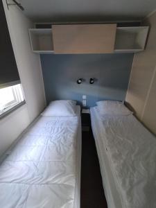 圣让-德蒙Mobil home Vendée的一间设有两张床的客房,