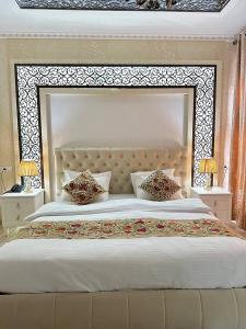 布哈拉Grand Nodirbek Boutique Hotel的卧室内一张带大床头板的大床