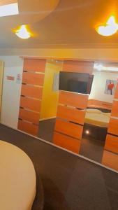 格拉玛多阿维尼达汽车旅馆（仅限成人入住）的客房设有木制橱柜和一张床。