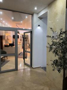 多布拉沃达Lux Hotel M的大堂设有滑动玻璃门和盆栽