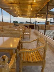布哈拉Hotel Saidkasim with a Terrace的餐厅里一排桌子和长椅