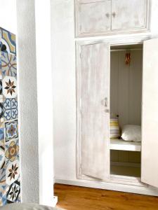 EspinardoGuest house Croqueta Espinardo的一间白色橱柜内带镜子的卧室