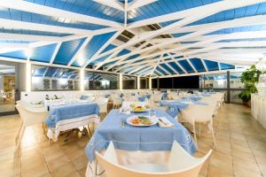 帕利努罗圣塔卡特林纳酒店的用餐室配有蓝色桌子和白色椅子