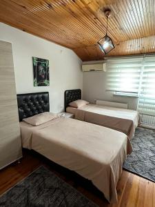 特拉布宗GÖKTÜRK APART的一间卧室设有两张床和木制天花板