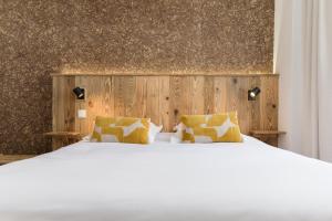 博福特Hôtel Maison Doron的卧室配有白色的床和木墙