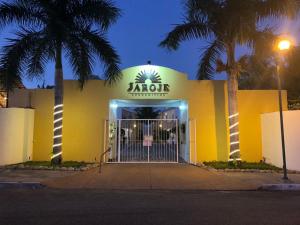 圣克鲁斯华特库Condominios JAROJE的黄色建筑,标有阅读zago餐厅的标志
