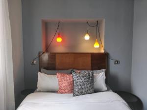 费拉约港al 28 B&B的床上有四个枕头,上面有两个灯