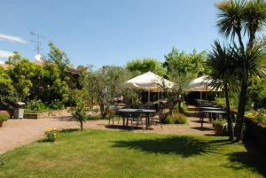 马内尔巴洛坎达达维托里奥酒店的花园内带桌子和遮阳伞的庭院