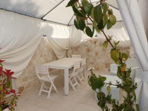 阿尔贝罗贝洛Mamapulia Home的帐篷内的白色桌椅