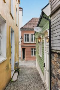 卑尔根Bryggen Living的一条狭窄的小巷,有绿色和白色的建筑
