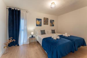 梅里达Apartamento Turístico ALHMA HOME的一间卧室配有两张蓝色床单