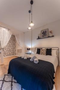 梅里达Apartamento Turístico ALHMA HOME的一间卧室配有一张带蓝色毯子的大床