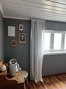 弗洛姆Indreli feriehus的客房设有带白色窗帘和桌子的窗户。