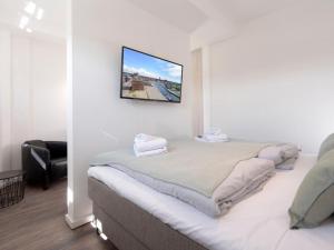 维斯马Ohlerich Speicher App. 19 - Meerblick的卧室配有一张床铺,墙上配有电视