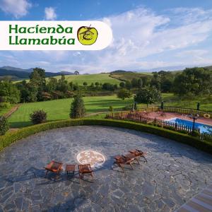 纳维亚Hotel Hacienda Llamabua的一个带两把椅子的石头庭院和一个游泳池