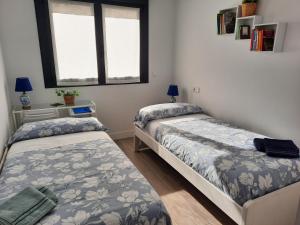 希洪Apartamento Dindurra Centro Playa的一间卧室设有两张床和窗户。