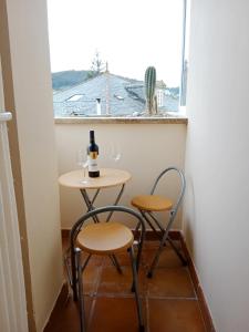 比韦罗Apartamento San Francisco的一张带两把椅子的小桌子和一瓶葡萄酒