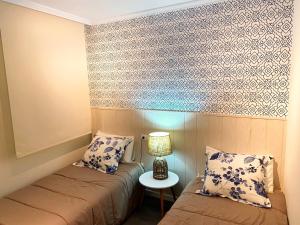 巴约讷Apartamento en Porta do Sol, Baiona的客房设有两张床和一张带台灯的桌子。