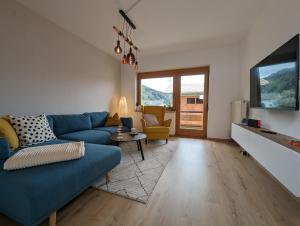 德布里阿赫Angerpartments-Sonnige große Wohnung mit Balkon und kostenlosen Parkplatz的客厅配有蓝色的沙发和电视