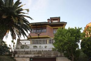 桑提亚纳德玛Villa Marta的带阳台和棕榈树的大房子