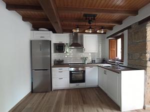 坎加斯-德奥尼斯Aromas de Coraín的一间厨房,配有白色家电和木制天花板