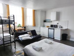 布莱顿霍夫Kipps Brighton的一间带一张床的客厅和一间带沙发的厨房